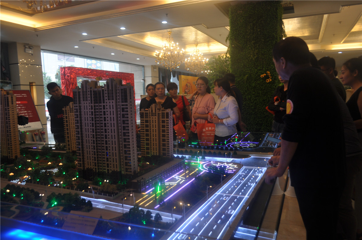 客戶聚集在沙盤前聽(tīng)講解