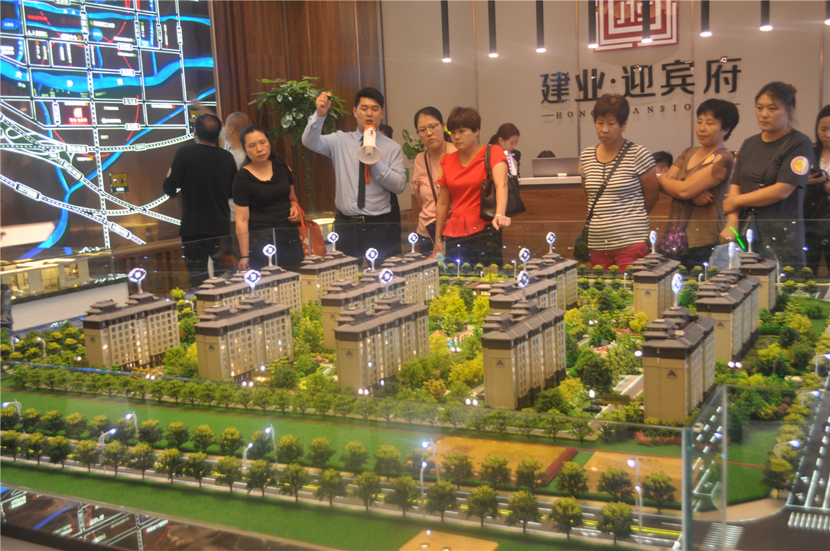 客戶圍著沙盤認真聽取意見